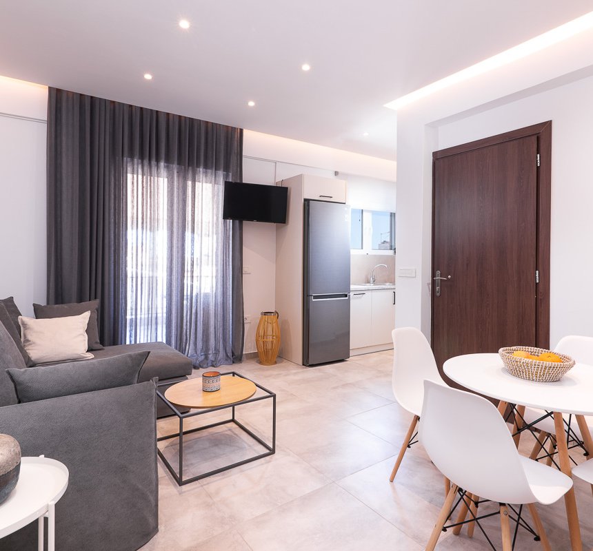 Το σαλόνι του Premium Apartment του Lithies Zante Living. Μεγάλος καναπές και τραπέζι με τέσσερις καρέκλες.