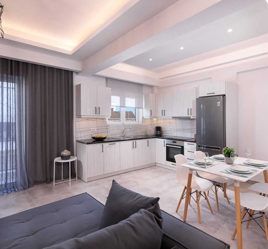 Το σαλόνι του Deluxe Apartment του Lithies Zante Living. Μεγάλος καναπές και μπαλκόνι.