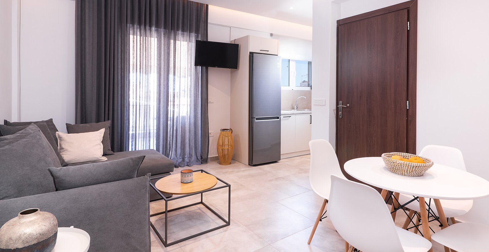 Το σαλόνι του Premium Apartment του Lithies Zante Living. Μεγάλος καναπές και τραπέζι με τέσσερις καρέκλες.