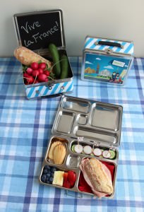 France Bento Box with Little Passports Lunchbox on Blue/White Table Cloth