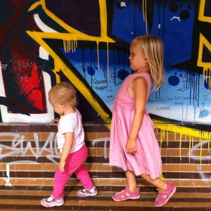 Little Passports Blog Raising Global Citizens in Paris Daughters in Front of Painted Wall