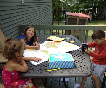 Three Children Playing with Little Passports World Edition