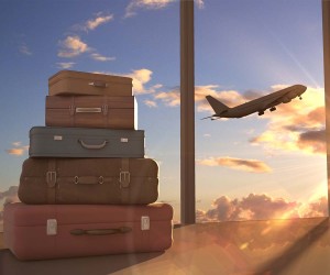 Suitcases stacked with airplane flying in background