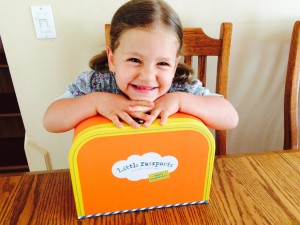 Little Passports Blog 5 Reasons Why Your Preschooler will love Early Explorers Girl Posing with Orange Suitcase