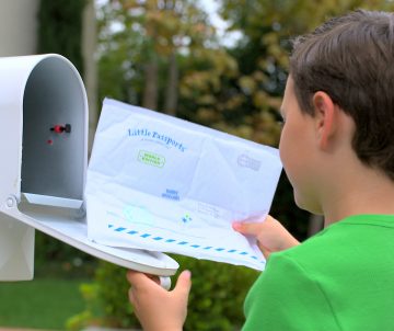 Boy in green shirt receiving world edition envelope in the mail