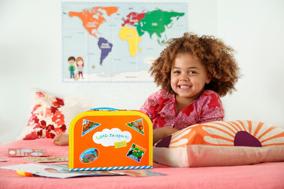 Girl on bed with Early Explorers Suitcase