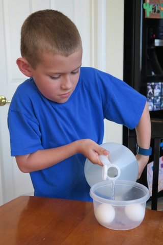 Boy pouring vinegar into container