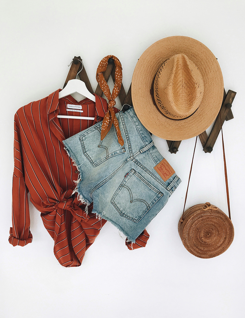 https://storage.googleapis.com/livvyland/2018/06/livvyland-blog-summer-outfit-inspiration-round-wicker-straw-handbag-levis-cutoff-shorts-striped-orange-button-up.jpg