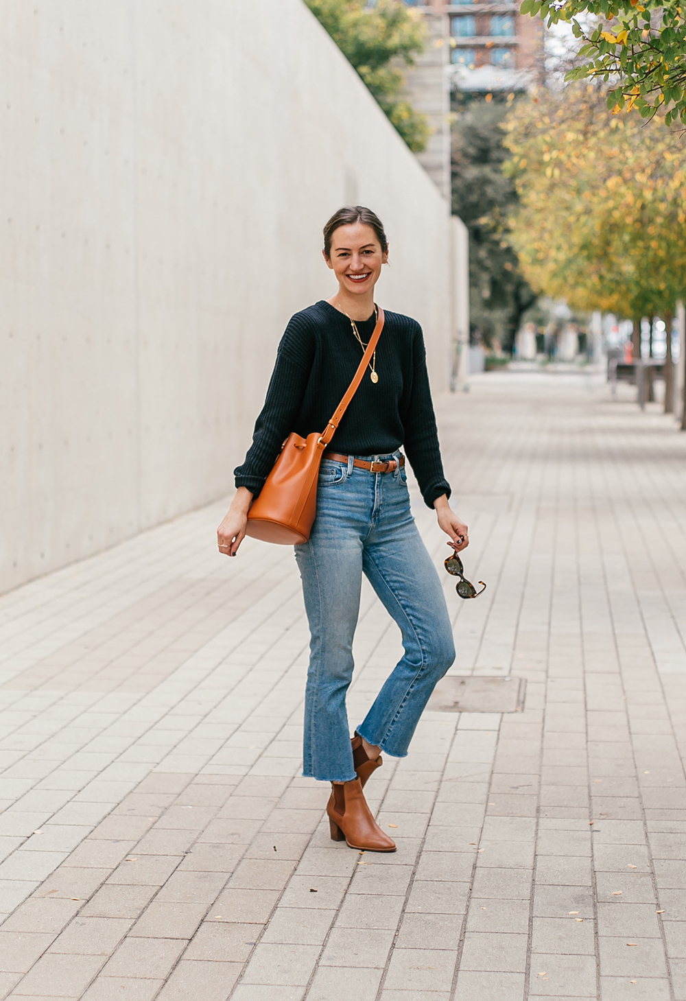 Chic layered fall outfit idea with camel sweater, black denim