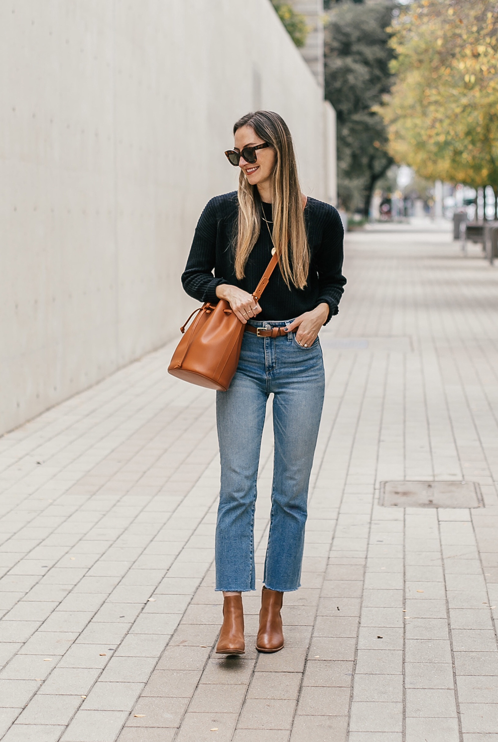 Chic layered fall outfit idea with camel sweater, black denim