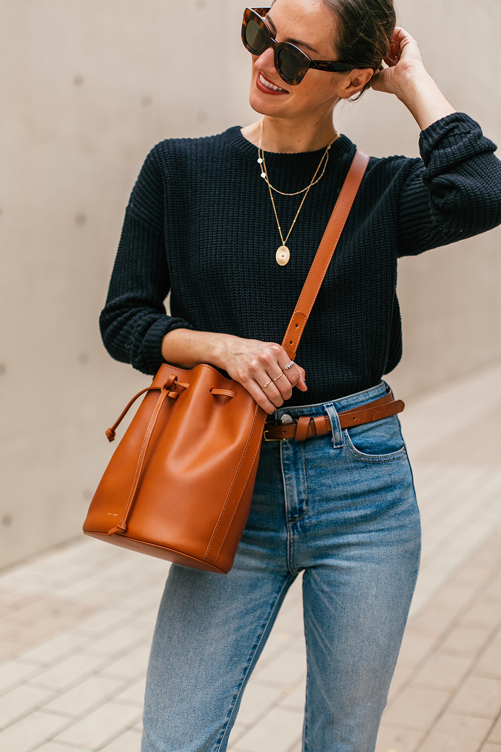 Chic layered fall outfit idea with camel sweater, black denim