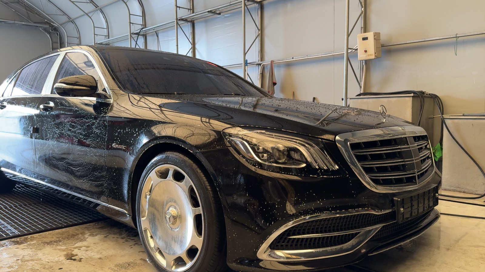 Water beading on the freshly washed hood and grille of a black Mercedes-Maybach at the LMN facility.