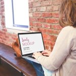 Woman sitting with Macbook on her knees