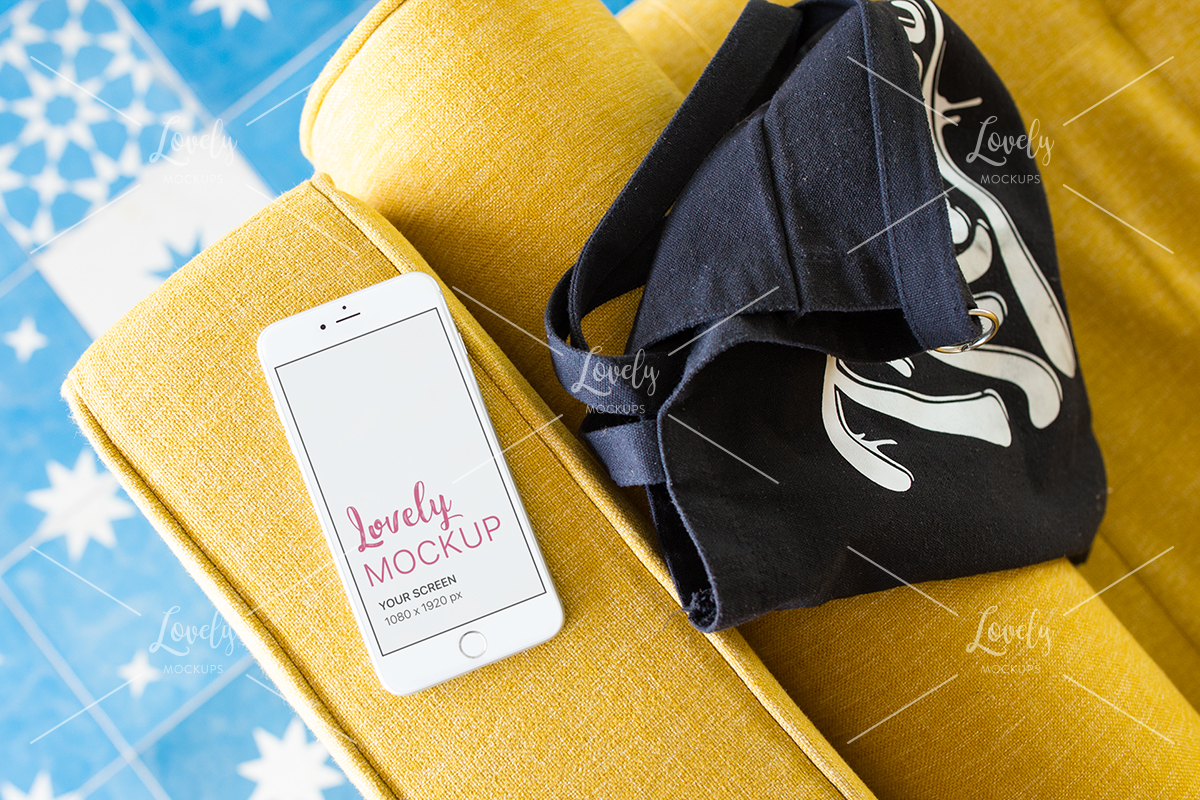 Download Iphone Mockup Lying On A Yellow Sofa Near A Bag Lovely Mockups