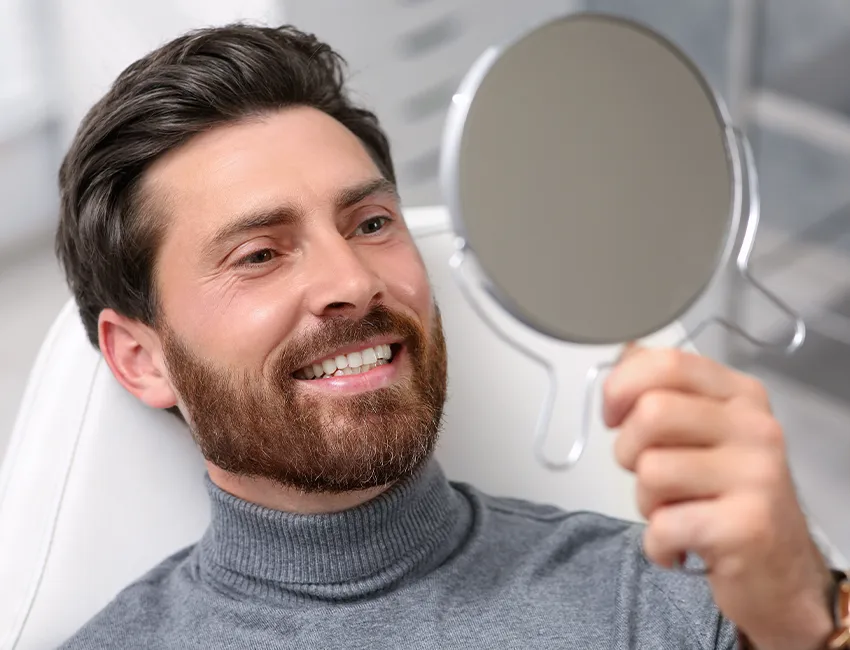 Male patient looking his tooth implant in Valencia, CA