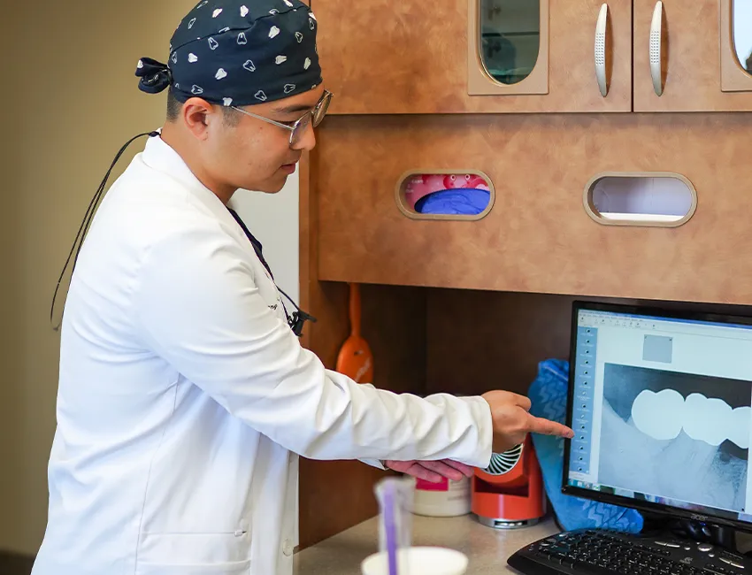 Dentist checking patient X-ray for dental bridge