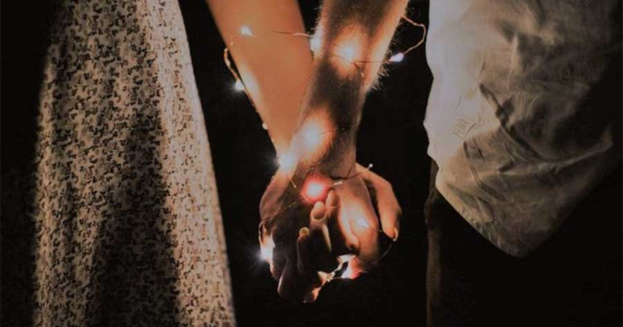 Fairy lights around hands.