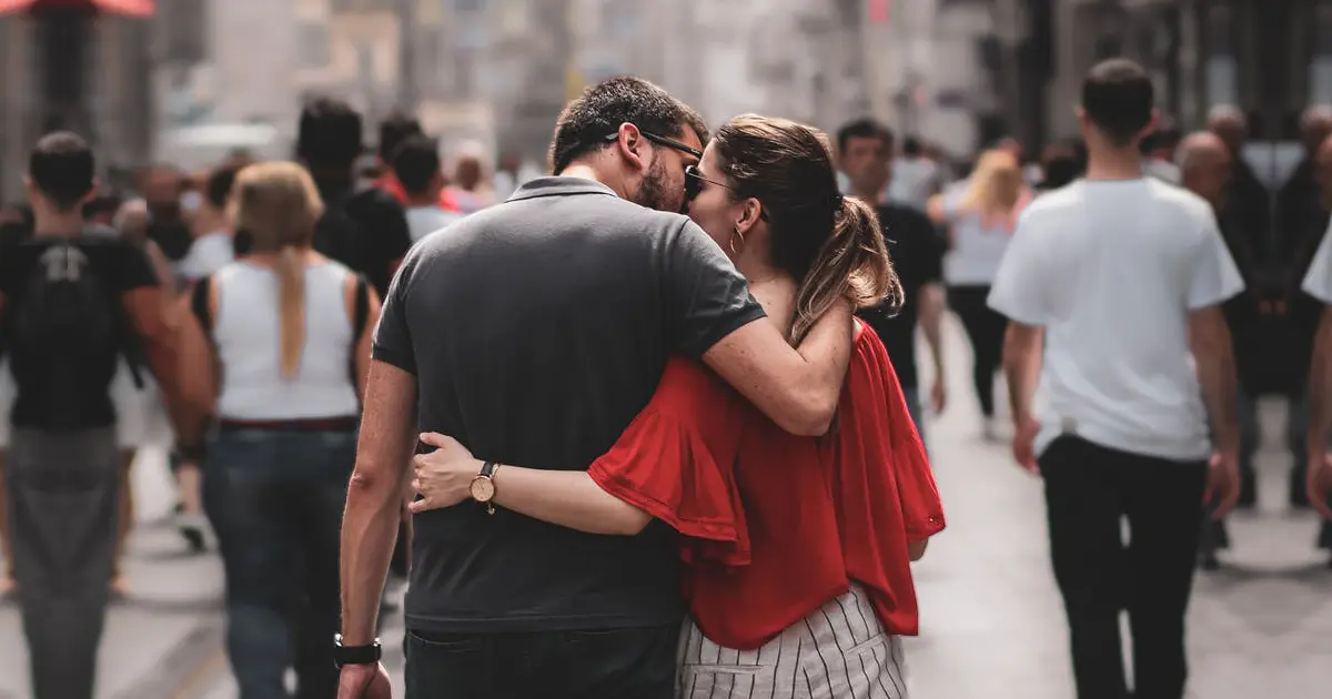 A photo of a couple walking together in a sea of other people