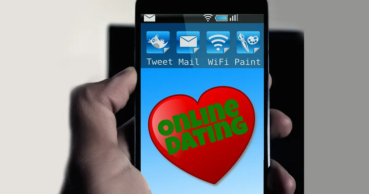 A smartphone displaying a heart with the text “online dating.