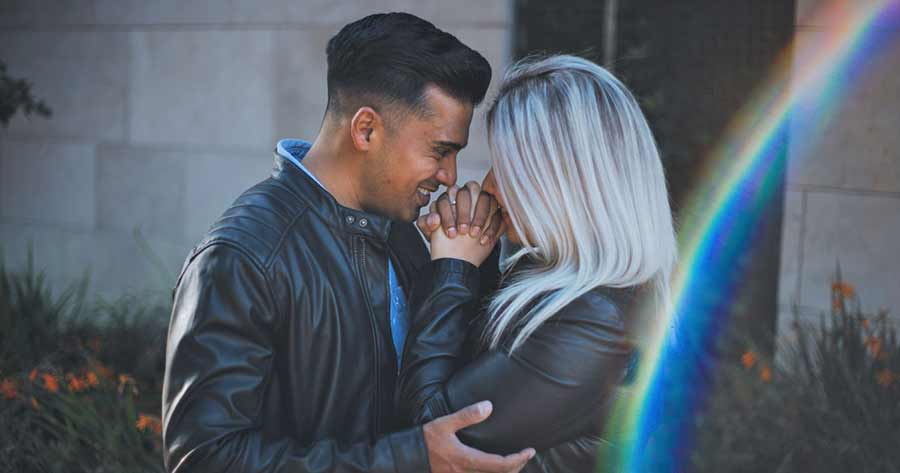 A photo of a couple holding each other’s hands.