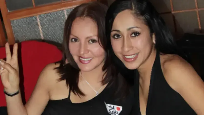 Women with peace signs smiling for the camera.