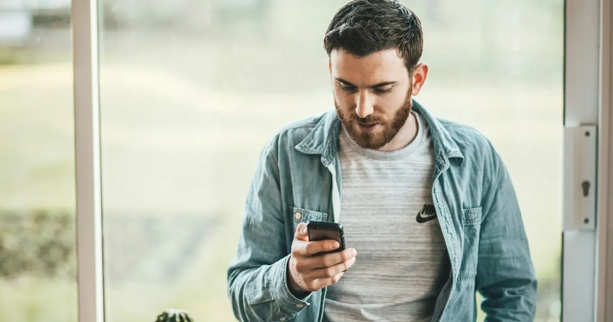 A man wearing a jacket hiding messages on his phone can be a form of micro cheating