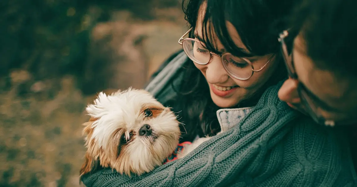 A DINK couple together with a dog being carried by the smiling girl