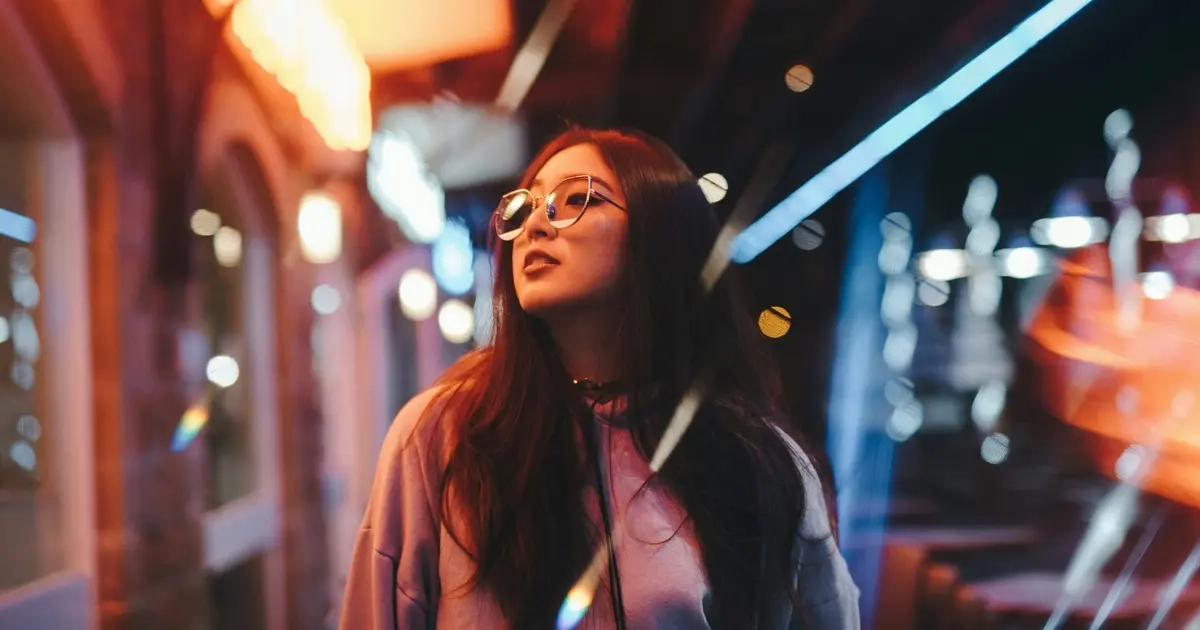 A young Asian woman wondering whether she needs to have a fully developed pre-frontal cortex before dating while out on the street at night