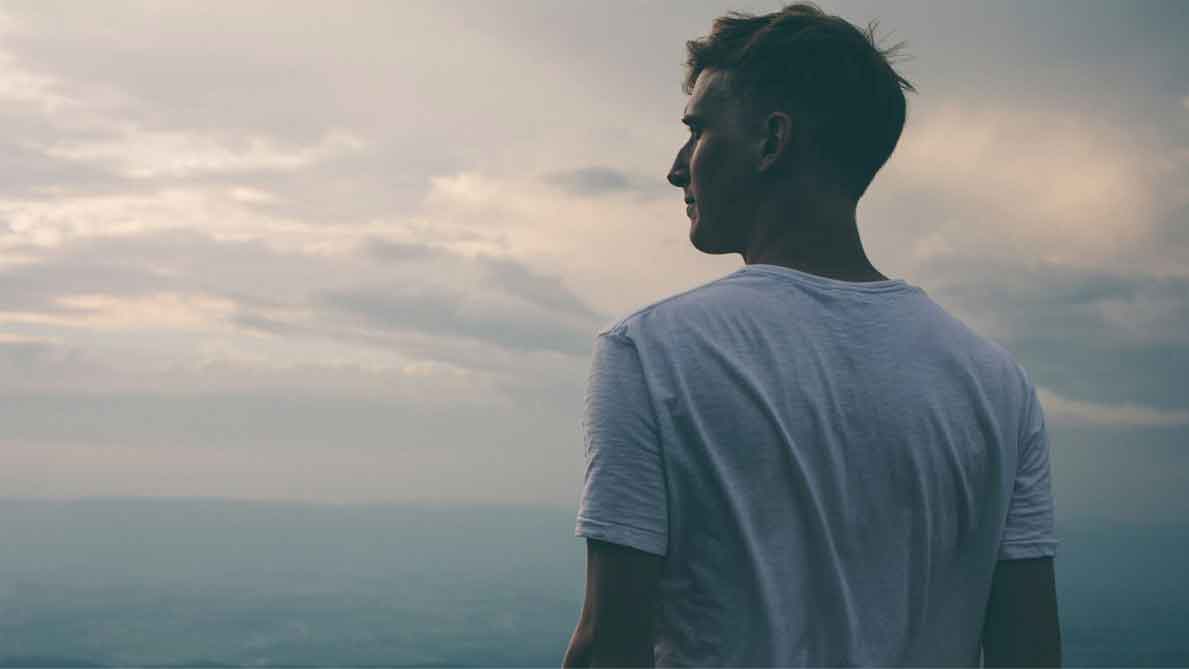 man looking at darkened sky