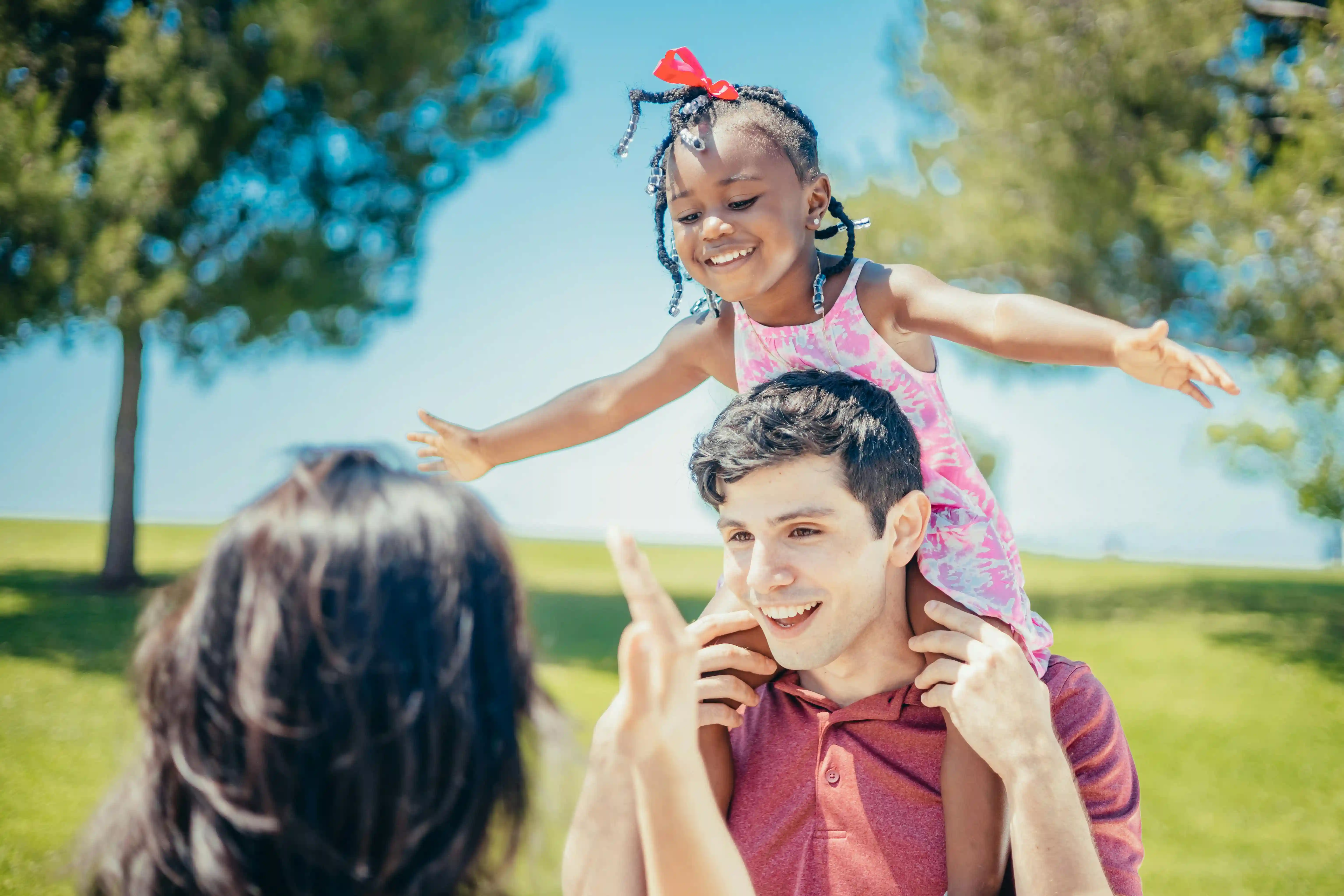 A man with a kid on his shoulders.