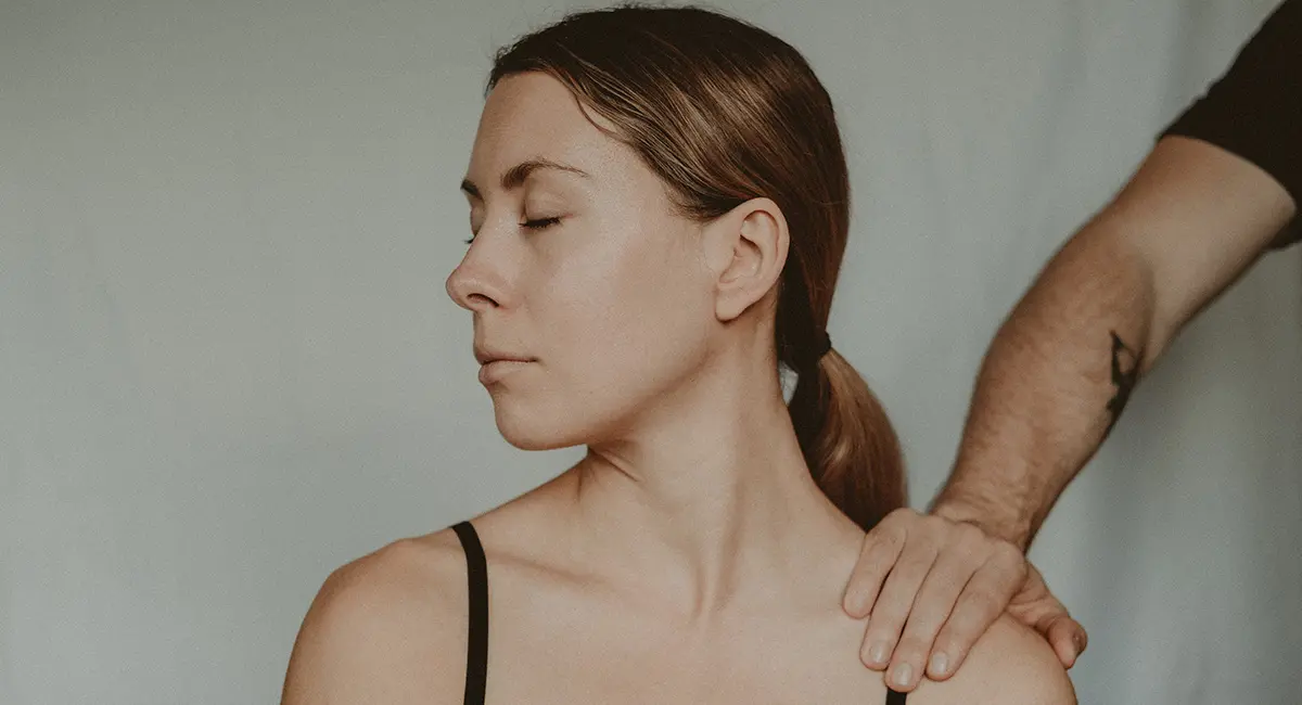 A woman looking away from a man tapping her shoulder.