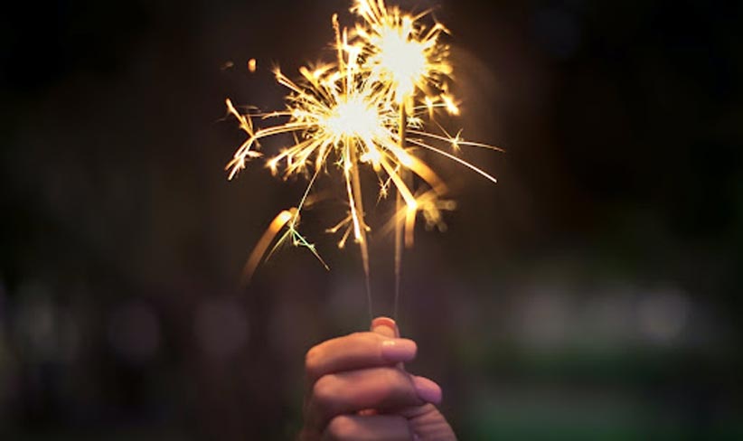 a hand holding up a sparkler