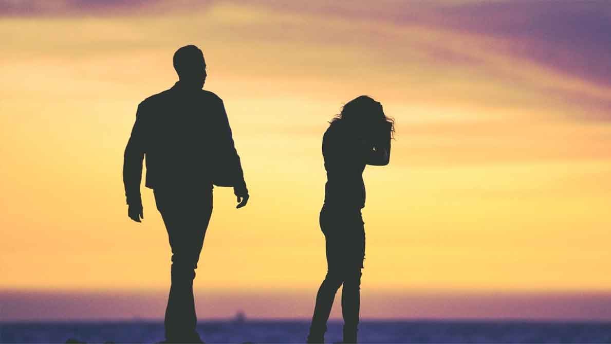man and woman at the beach during sunset