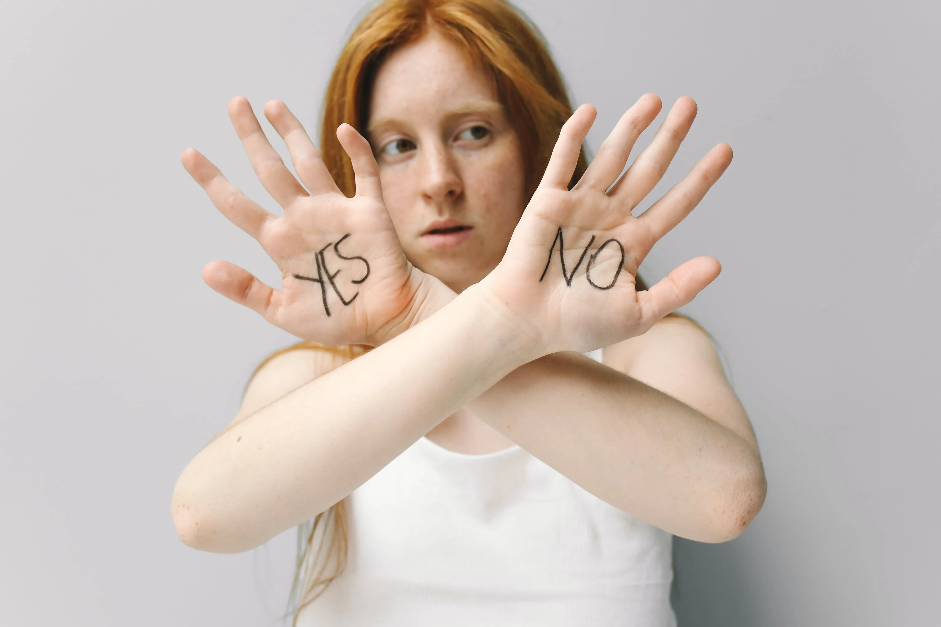 A woman with YES and NO written on her crossed palms.