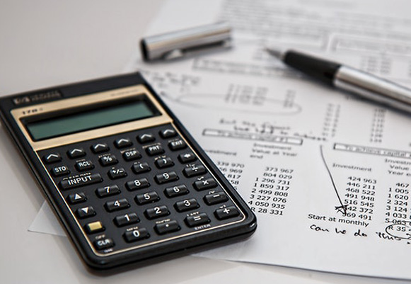 A photo of a calculator and pen
