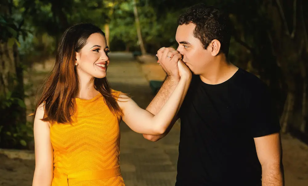 A couple holding hands, who seem happy with their relationship and commitment