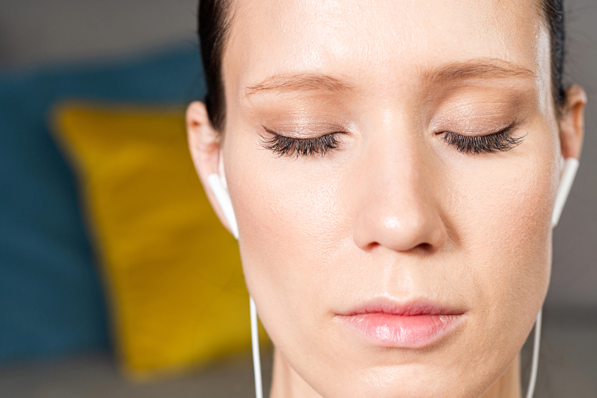 Woman with closed eyes listening to something through earbuds
