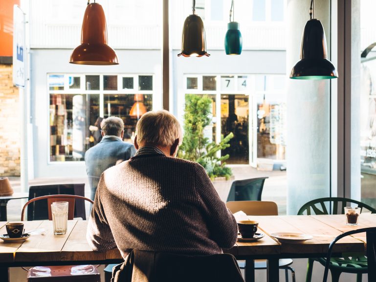 man sitting in open coffee shop