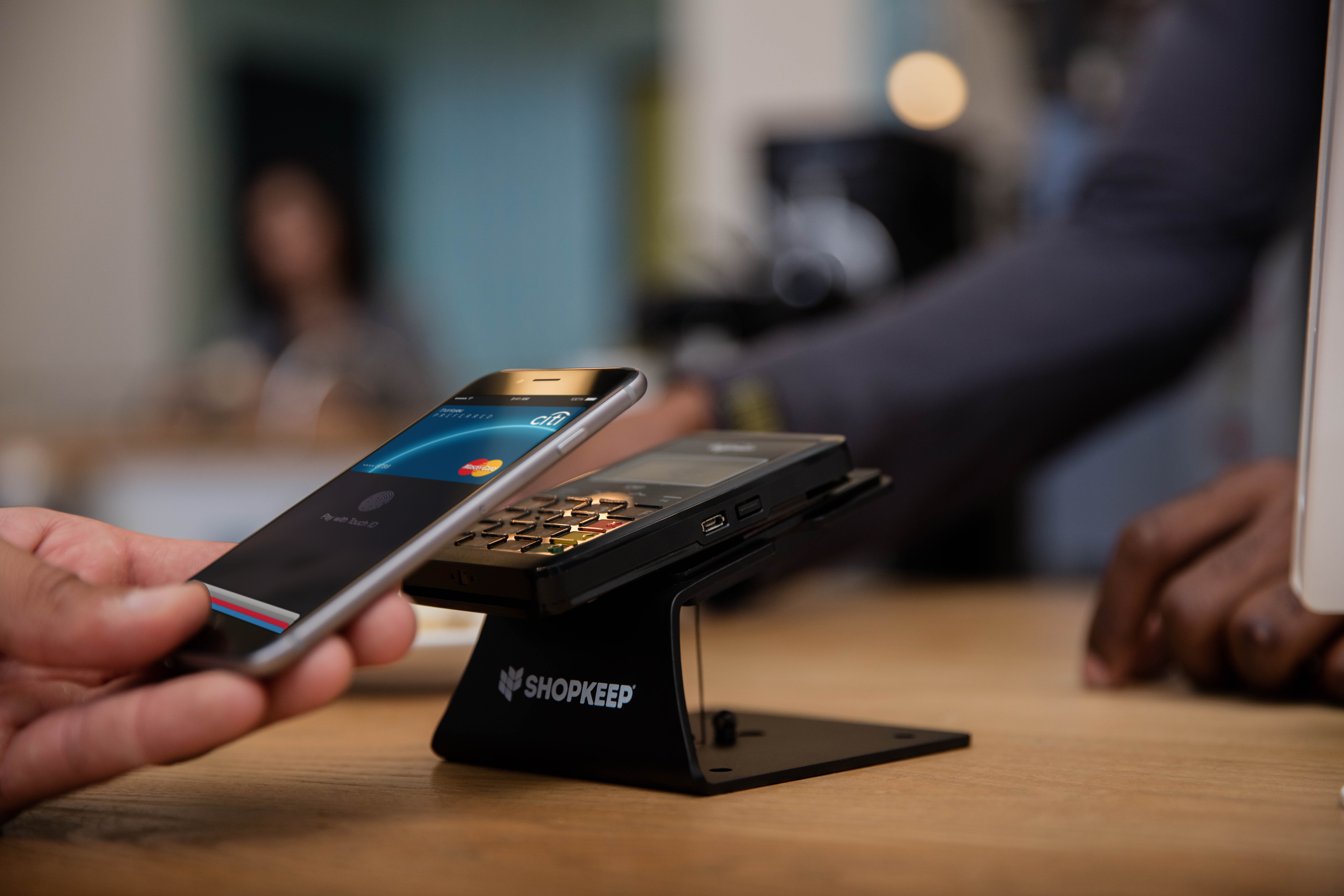 man using mobile wallet to pay for purchase with Apple Pay