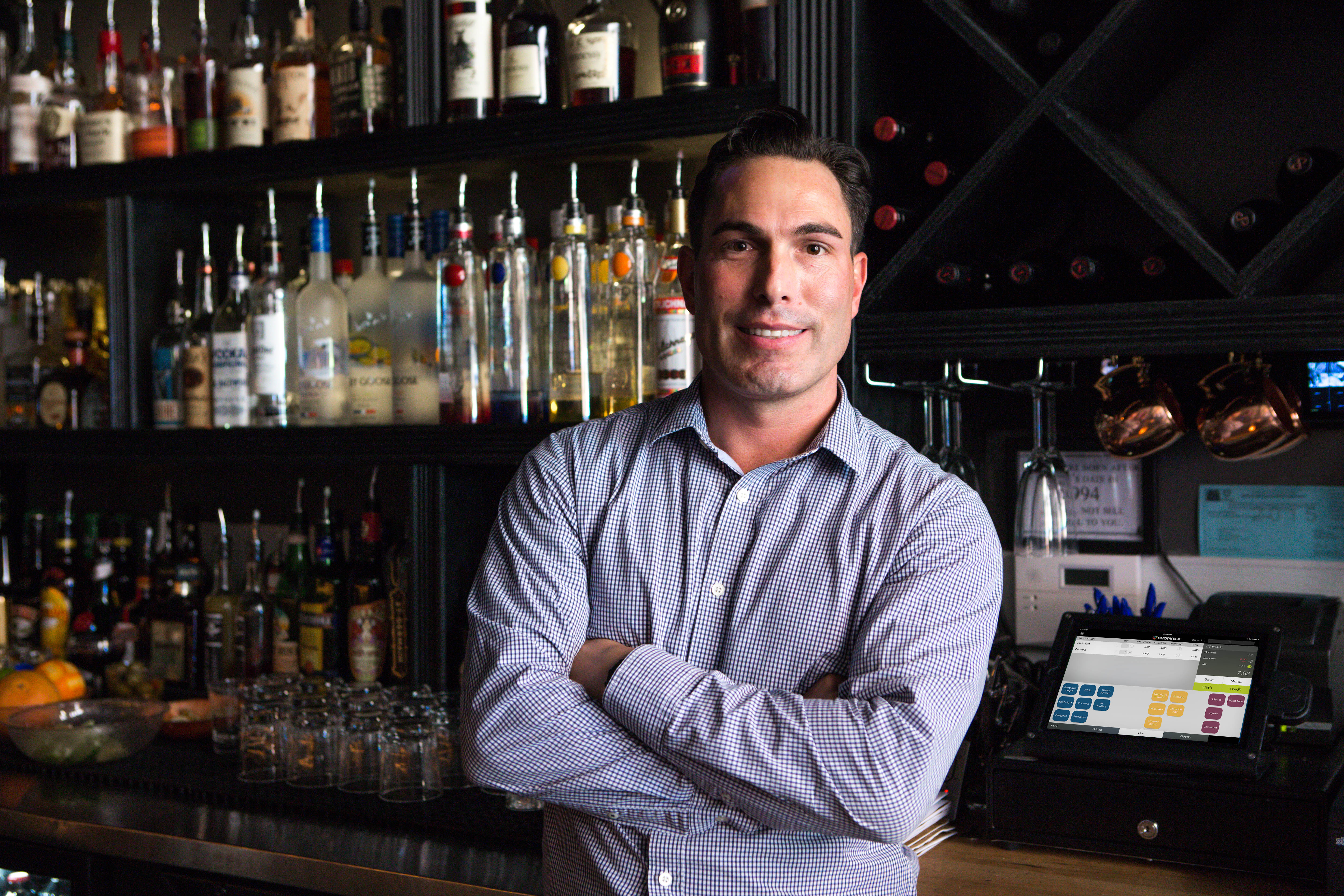 restaurant owner standing in front of pos system