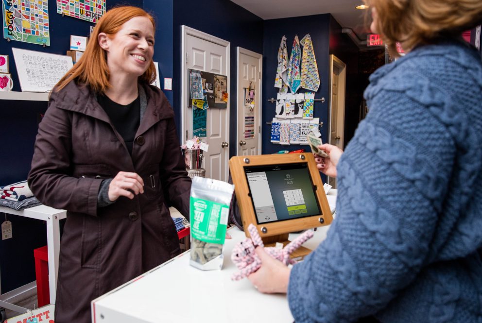 Smiling female customer purchasing an item at a pet store.