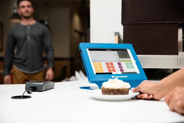 ShopKeep iPad POS system sitting on a counter next to a cupcake.