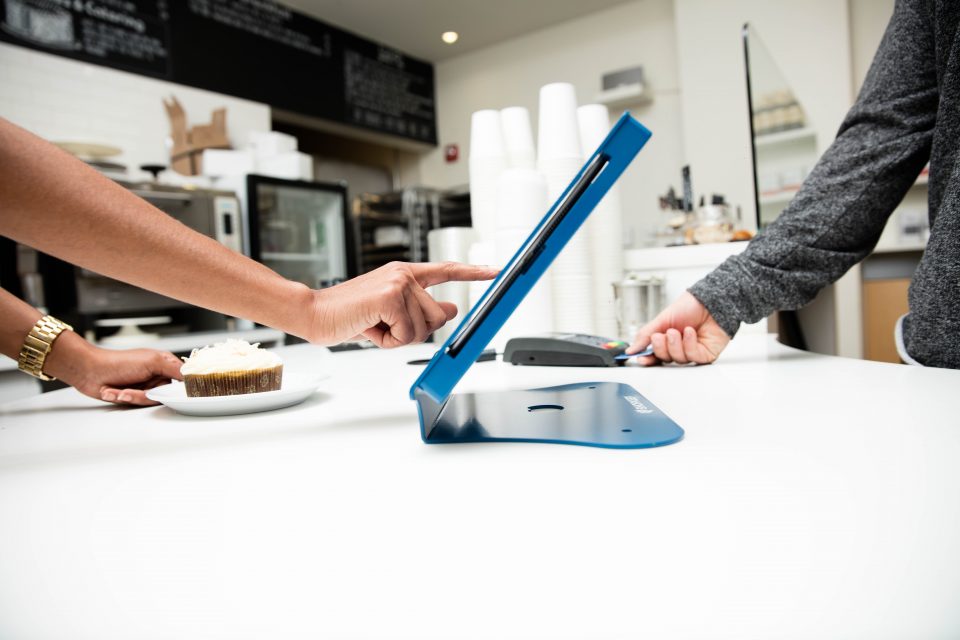 Retail employee entering an email address into a POS system.