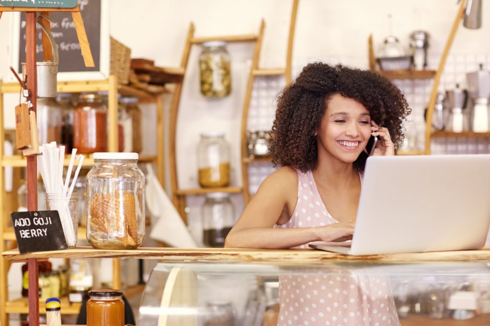 shop owner forecasting retail sales on her computer