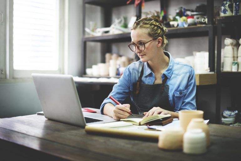 Small business owner working on her retail strategy by creating a sales report.