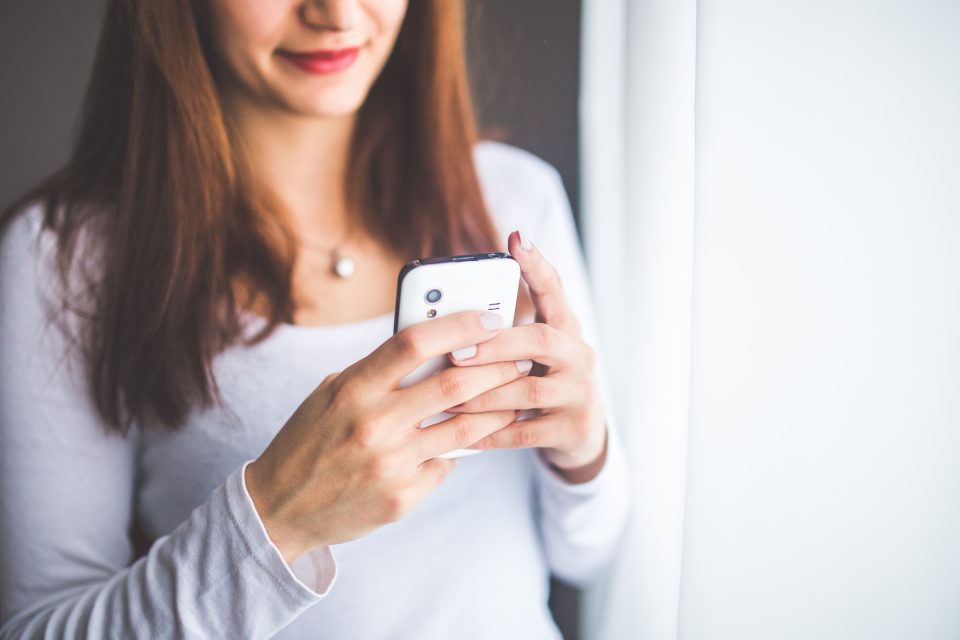 woman using Facebook on her phone