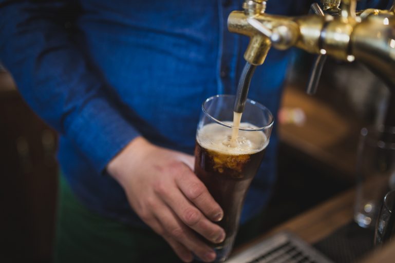 bartender filling glass with beer - business ideas for small towns