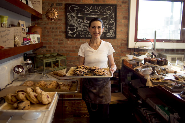 small business bakery owner holding pies - financing a business with credit cards