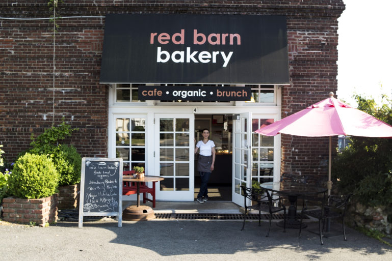 small business owner in front of her bakery - financing a business with credit cards