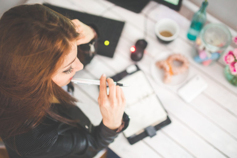 woman writing in day planner - time management tips for retailers